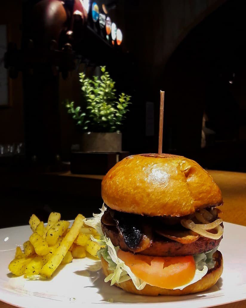 Hambúrguer vegetariano com cogumelos, cebola grelhada, alface e tomate, com batatas fritas