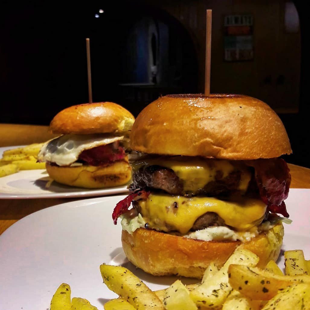 Hambúrguer duplo com queijo cheddar e bacon, servido com batatas fritas